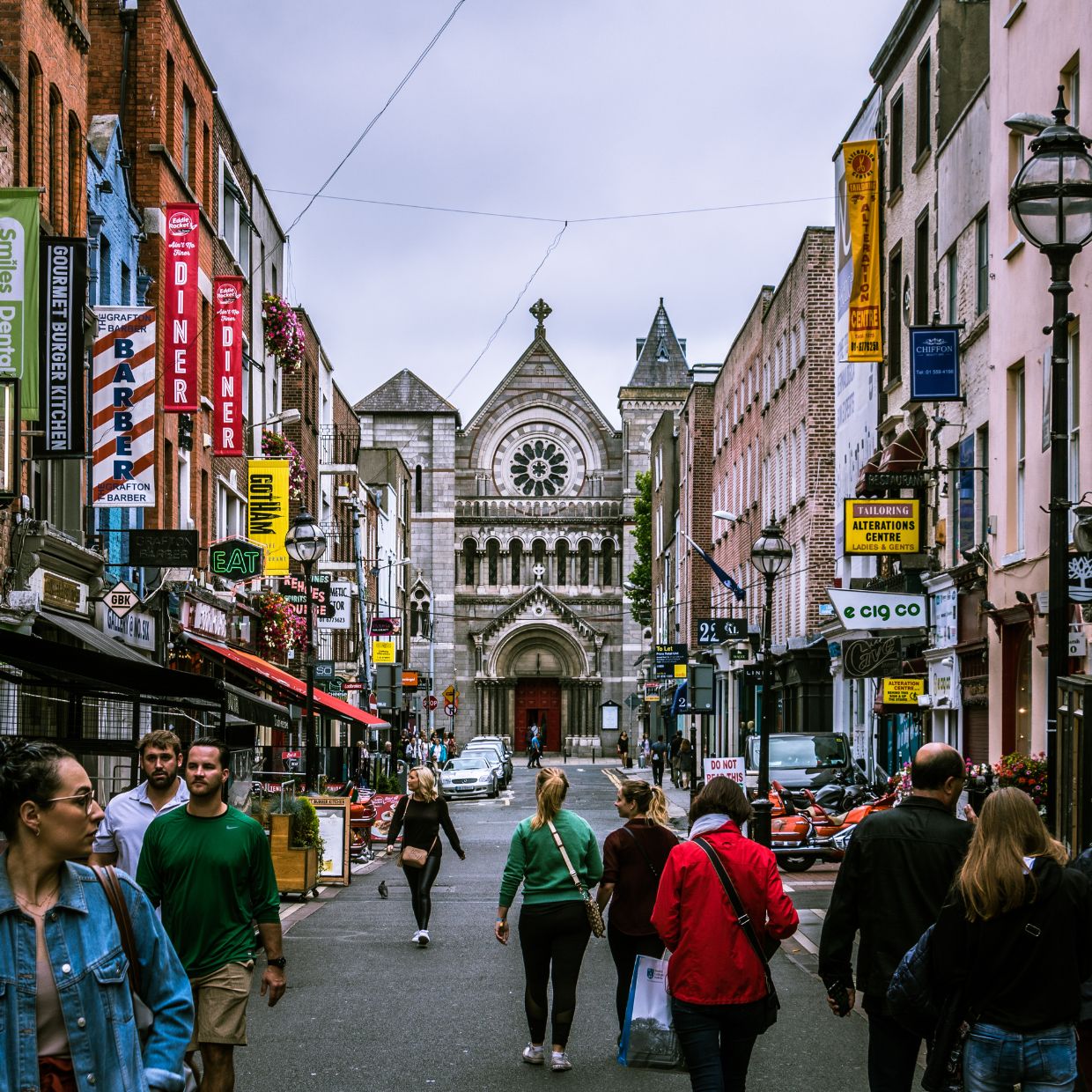Pedestrian street in Dublin city centre with historic church and colorful shopfronts